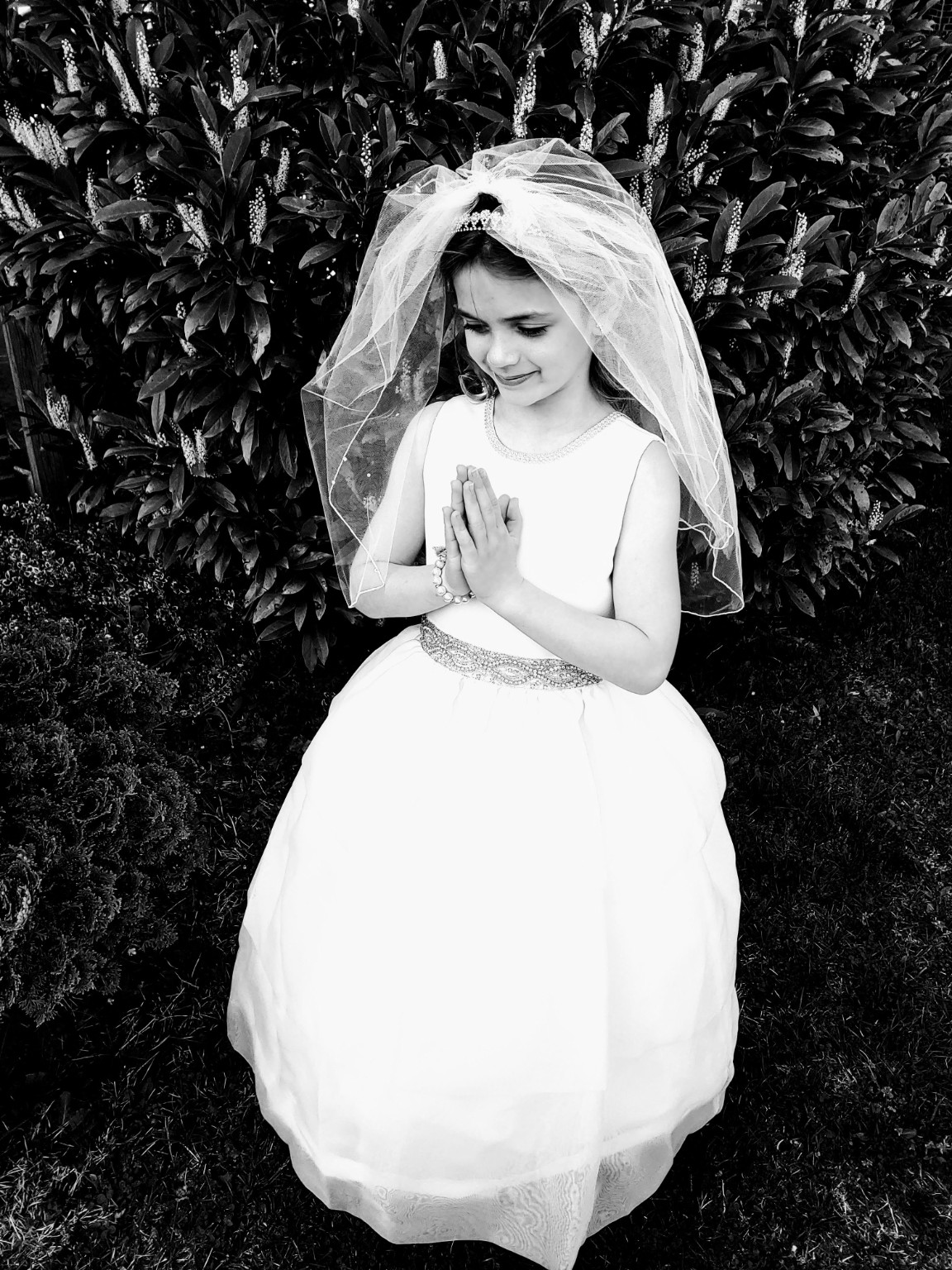 Black and white Communion portrait in a garden
