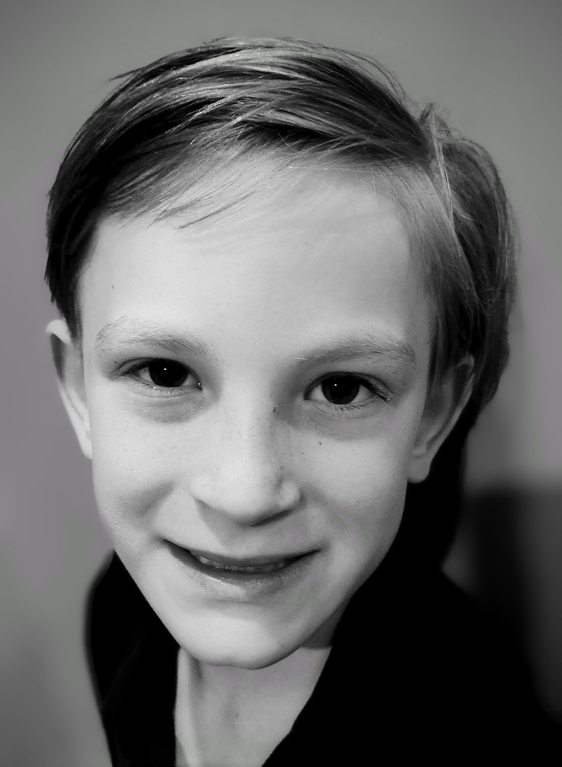 Black and white close-up portrait of a smiling boy
