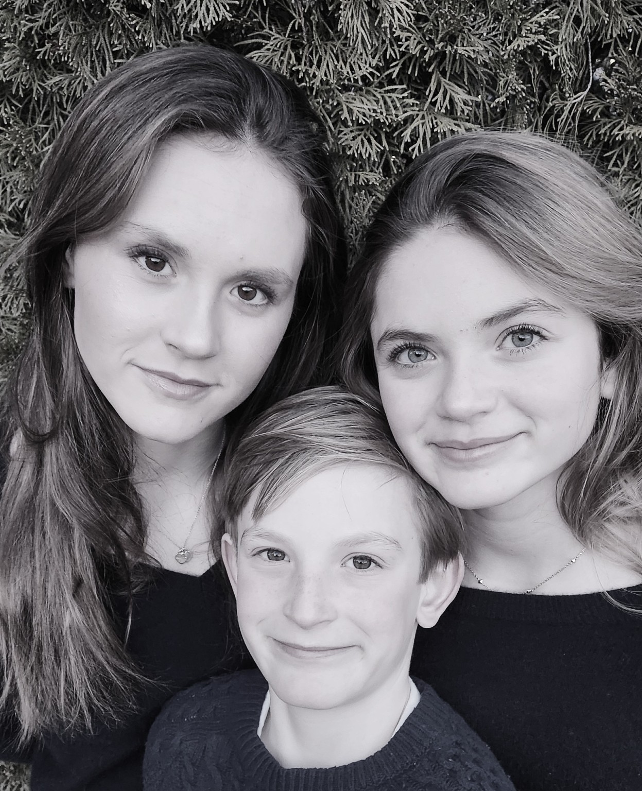 Black and white portrait of three siblings together outdoors